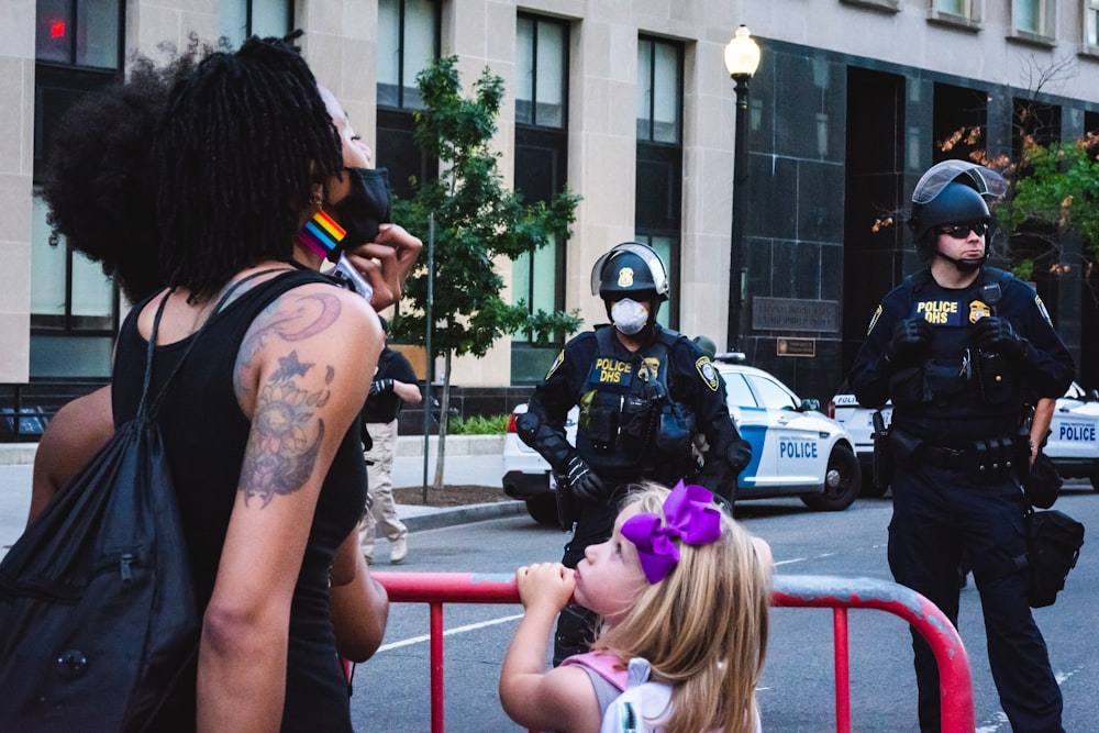 woman in black helmet and black vest with tattoo on shoulder standing on red metal railings