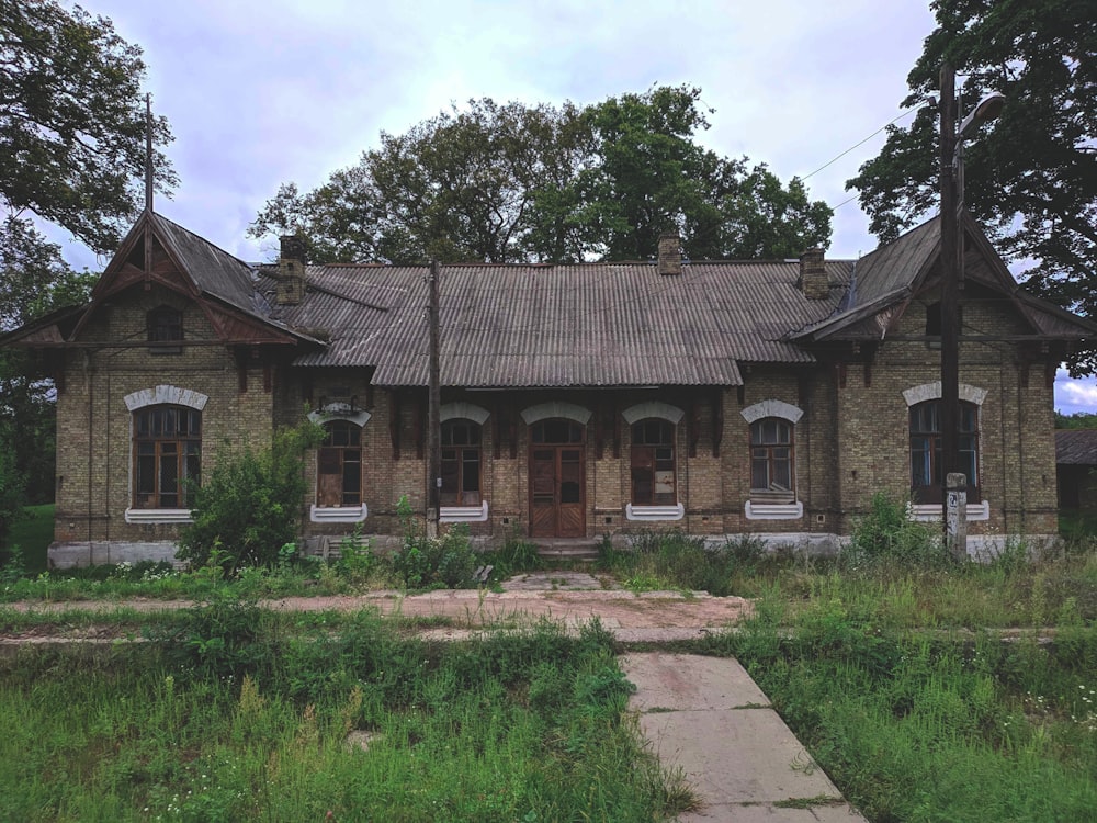 brown brick house near green grass field during daytime