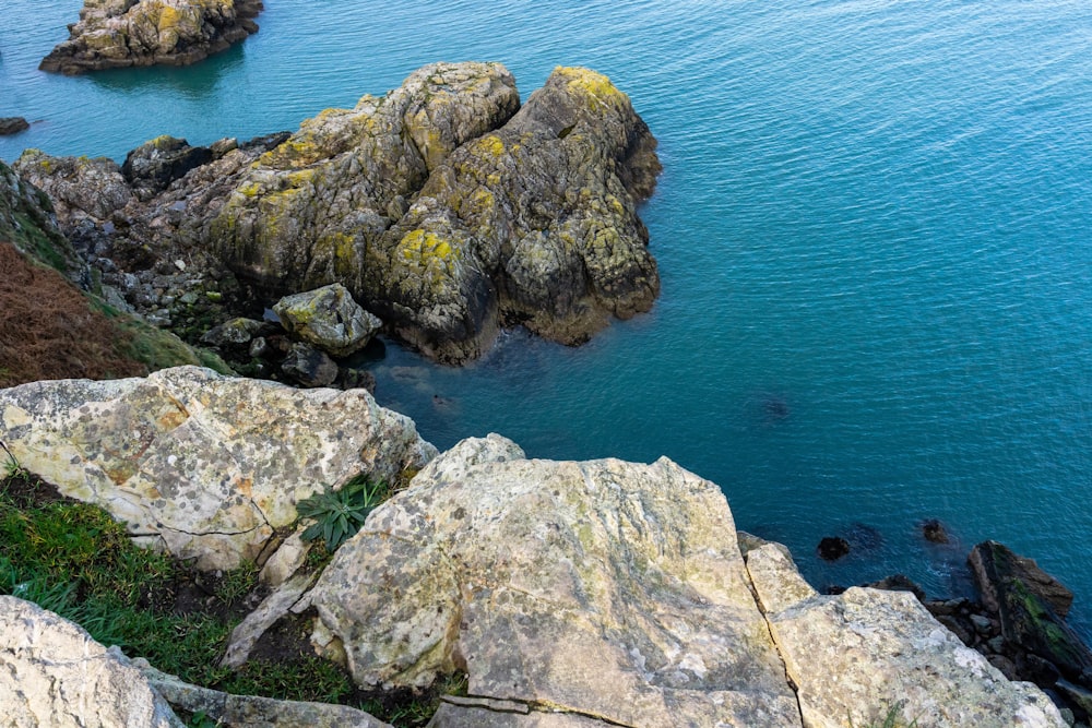 gray rock formation beside blue sea during daytime