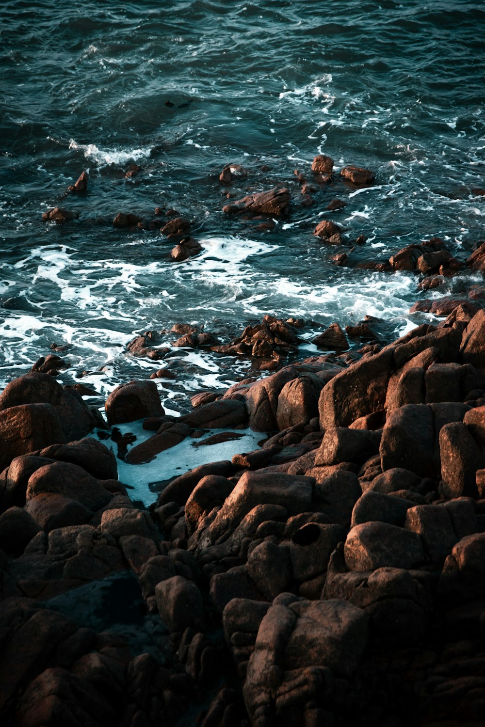rochas marrons no corpo de água durante o dia