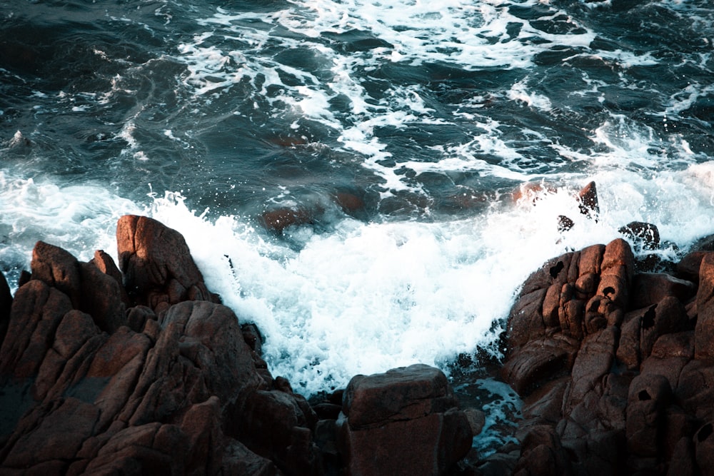 brown rocky shore with ocean waves during daytime