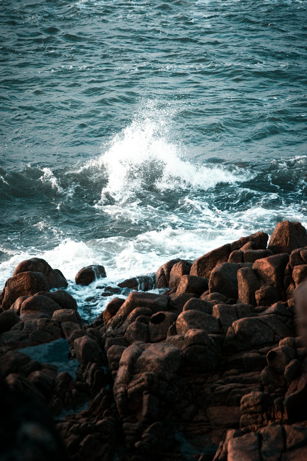 Rocas marrones cerca del cuerpo de agua durante el día