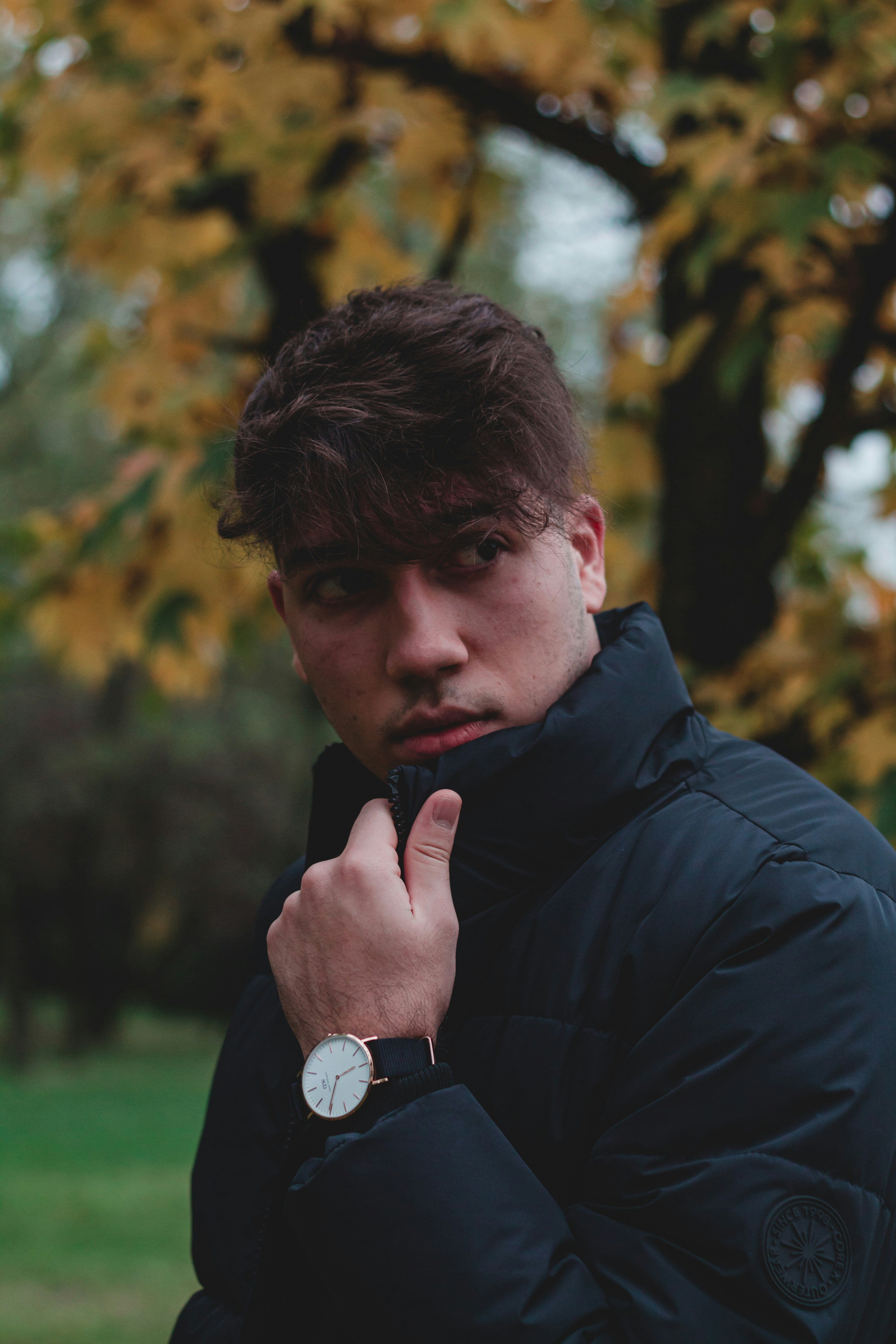 man in black jacket holding his chin