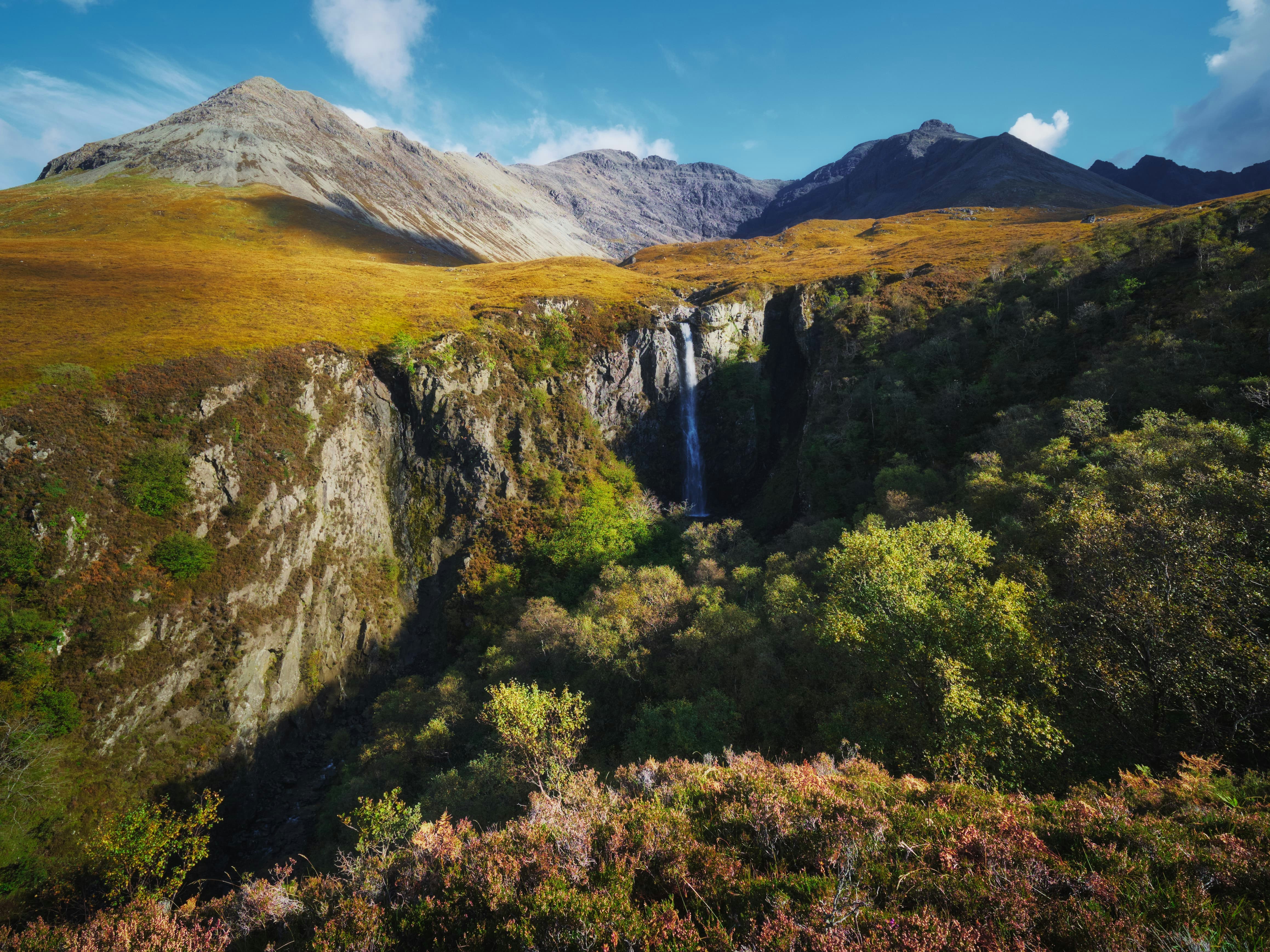 Further down Glen Brittle, towards its terminus as it pours out into Loch Brittle, you can hike up alongside less-visited rivers and their own waterfalls. Near the Glen Brittle Youth Hostel we park for a hike up the river Allt Coire Banachdich, as it pours down from the western flanks of the Black Cuillins. 300+ ft up the river this view suddenly opens up, revealing a deep and sheer gorge that the river has carved, now dropping 150+ ft as the waterfall known as Eas Mòr. A truly awe-inspiring site, especially with the western Black Cuillins above.