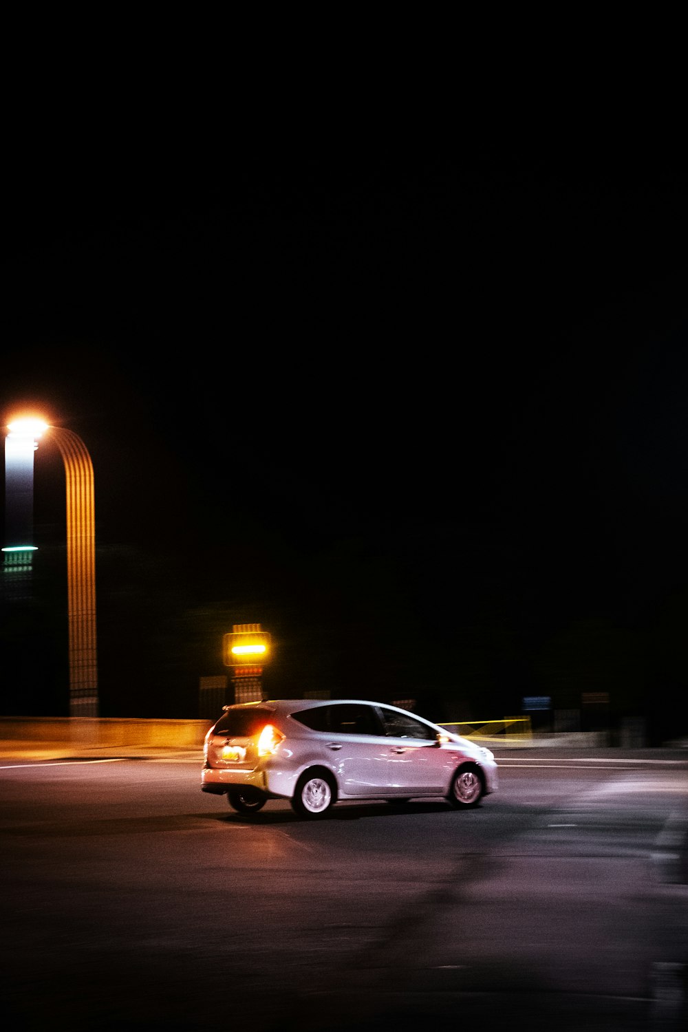 silver sedan on road during night time