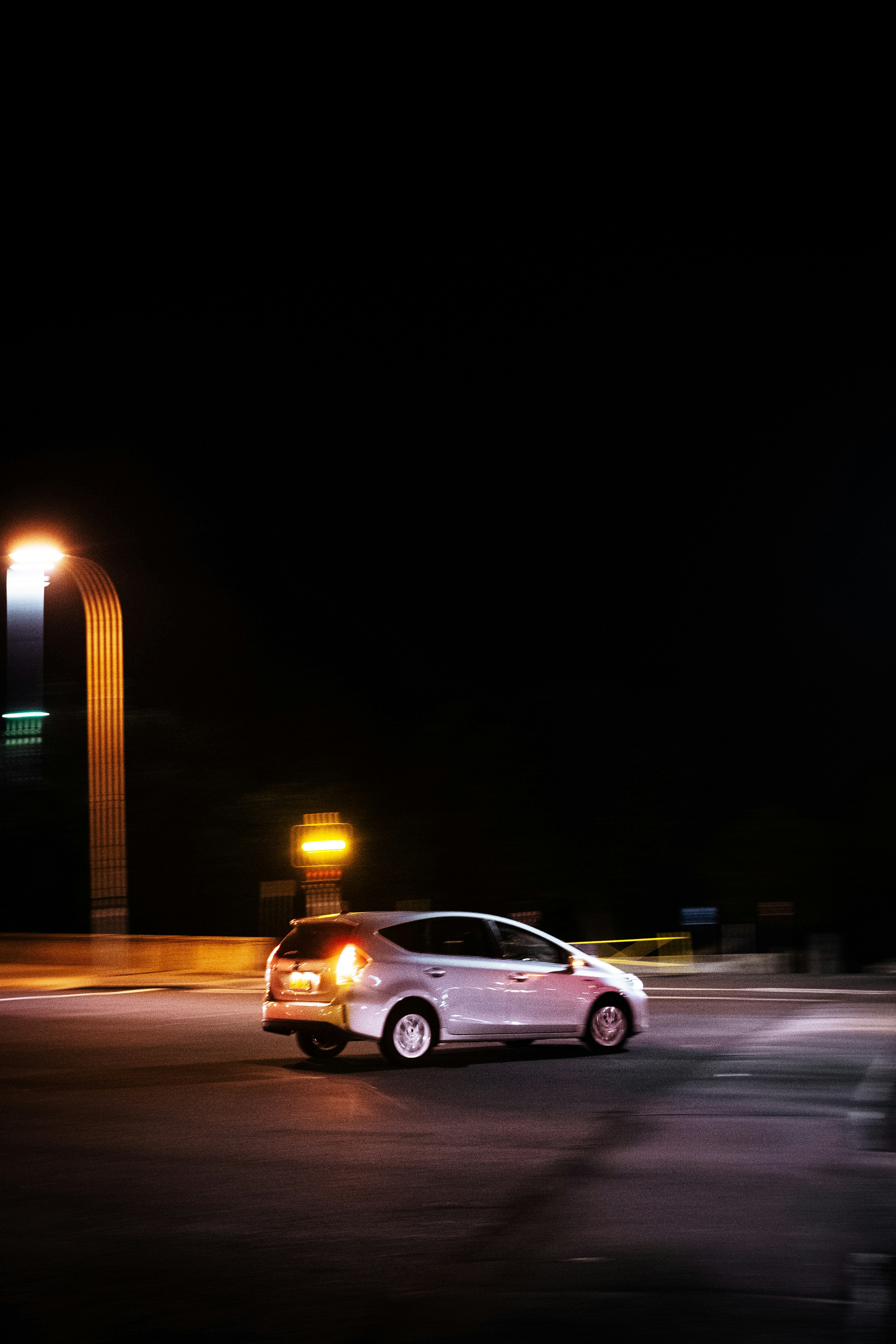 silver sedan on road during night time