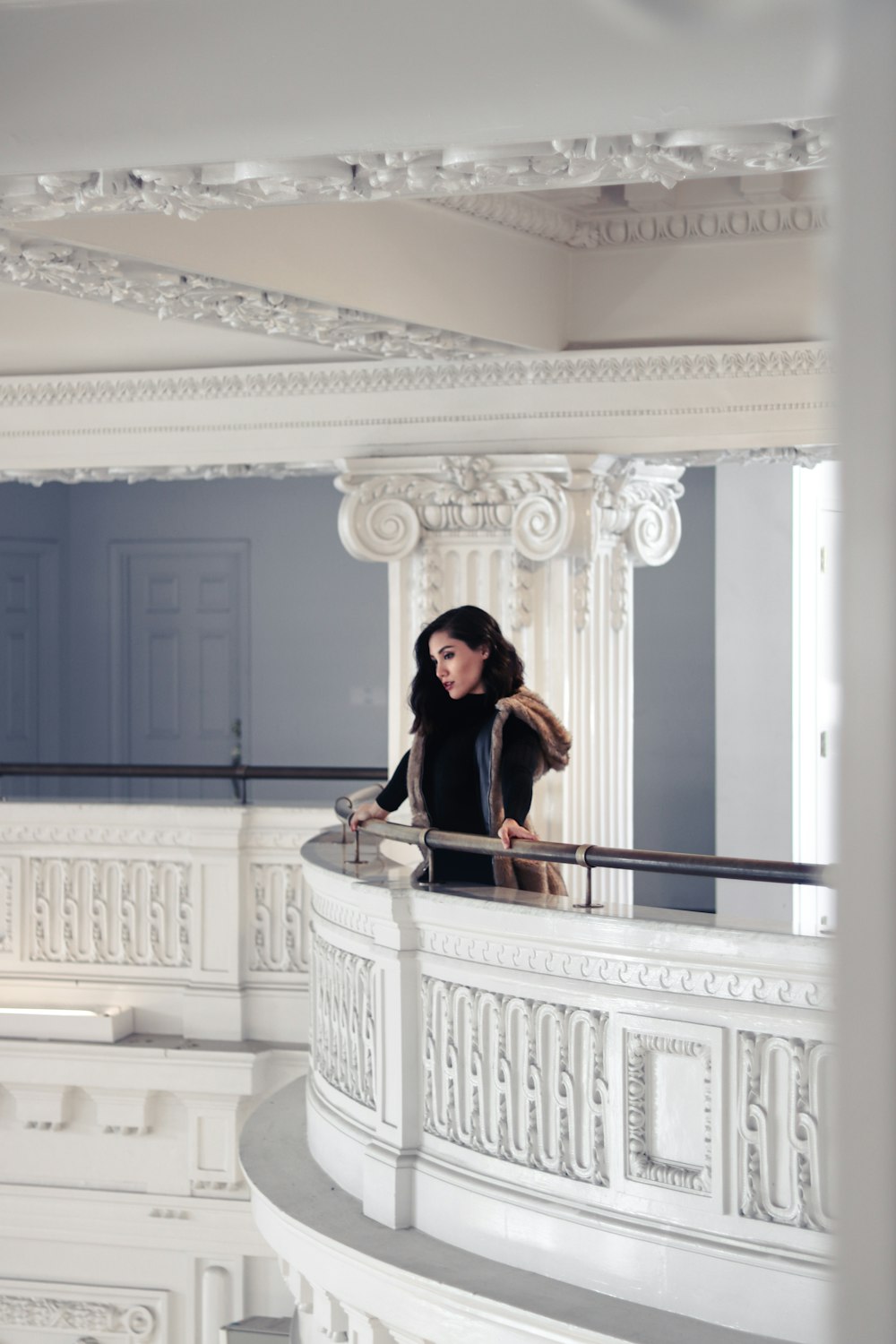 woman in black dress standing on white wooden staircase