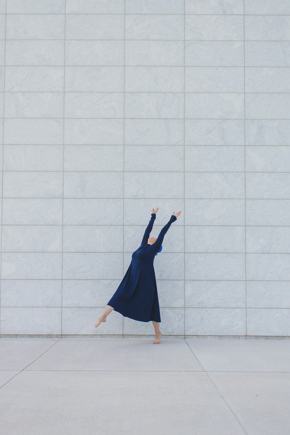 femme en robe bleue debout sur des carreaux de sol blancs