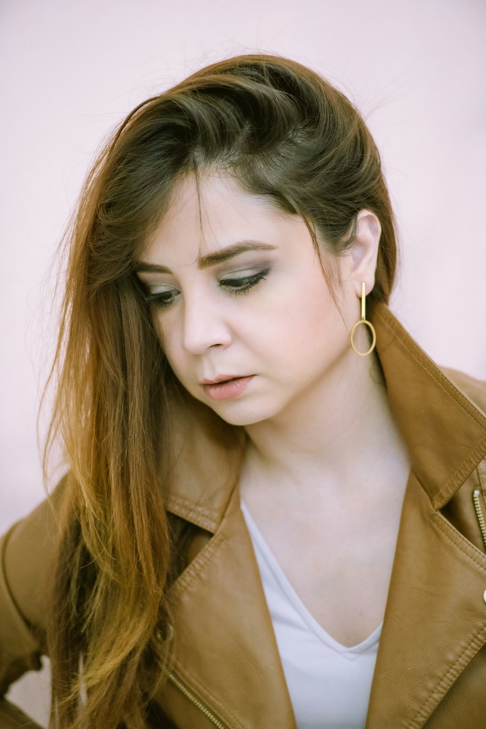 woman in brown coat wearing silver earrings