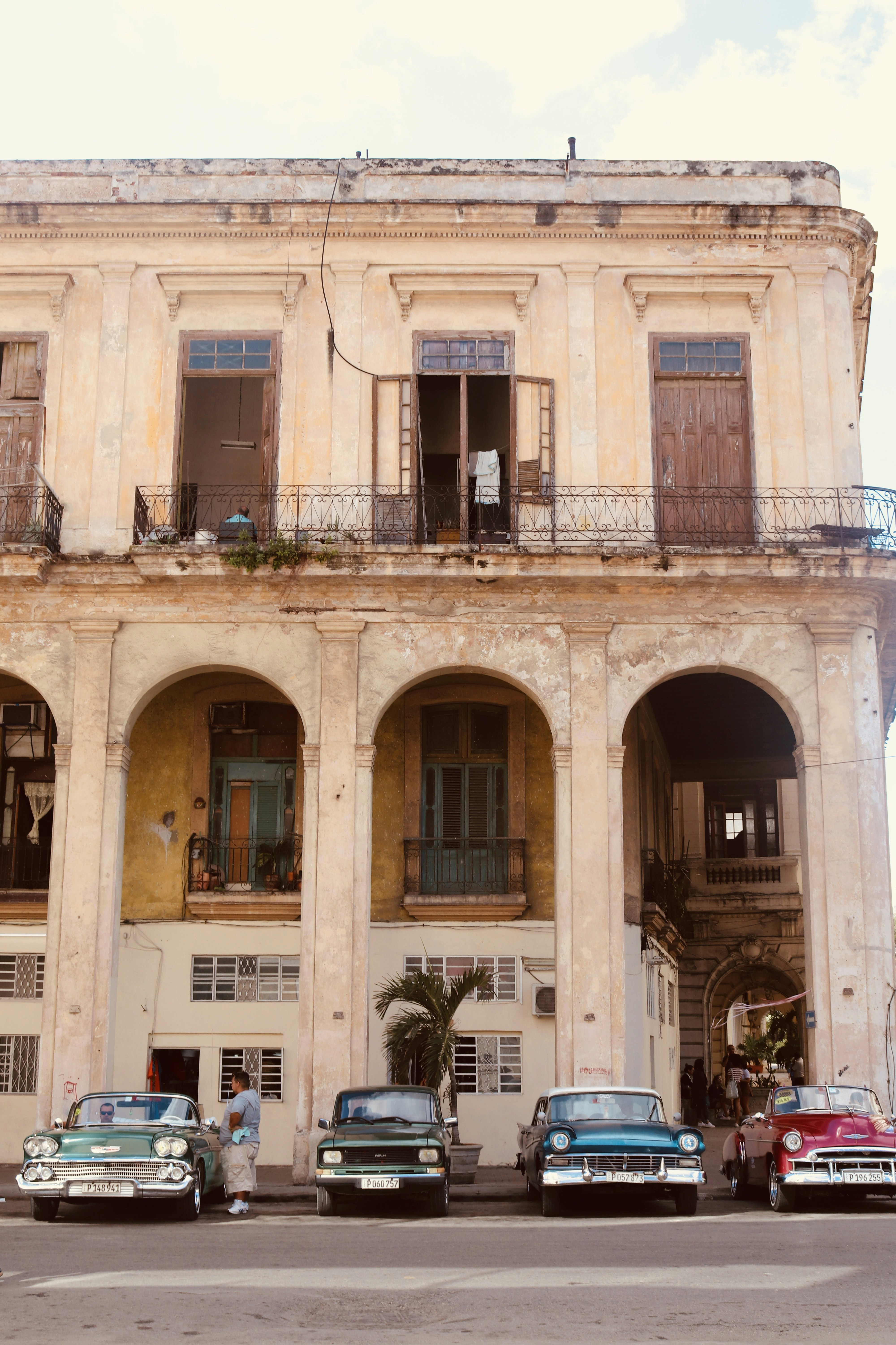 cars parked in front of brown concrete building during daytime