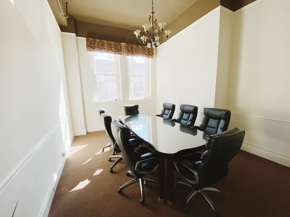 black office rolling chairs near white wall