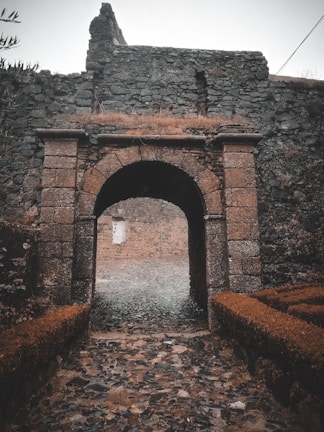 A misty ancient stone archway glowing faintly under moonlight.