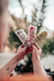 person holding brown and red labeled pack