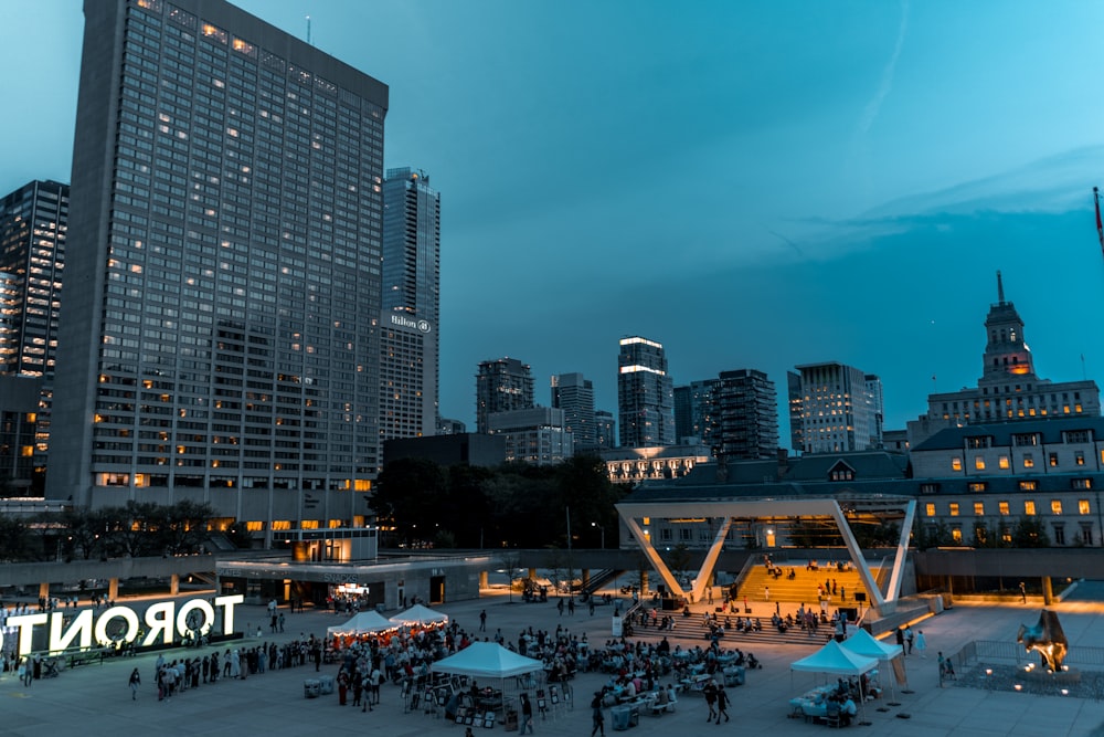 people on beach near high rise buildings during night time