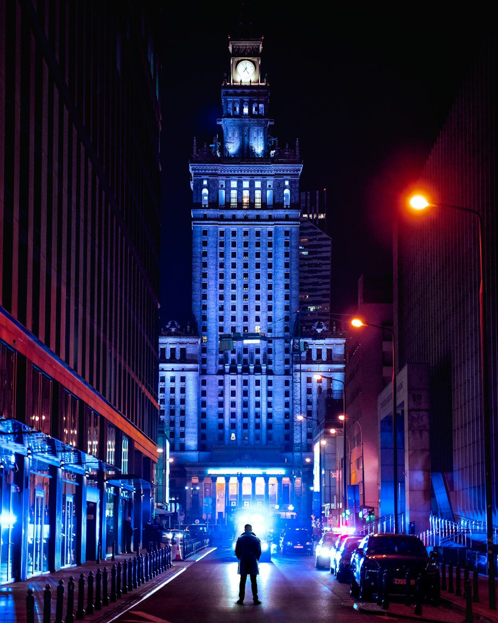 people walking on sidewalk near high rise buildings during night time