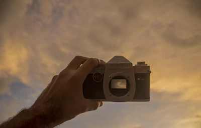A cinematic shot of a vintage camera capturing a sunset scene.