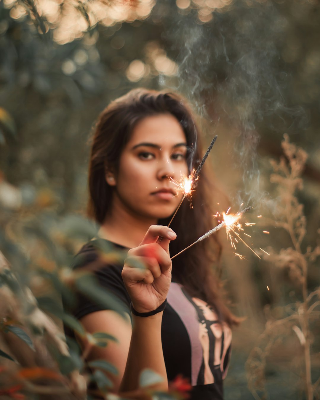 woman in black tank top holding sparkler