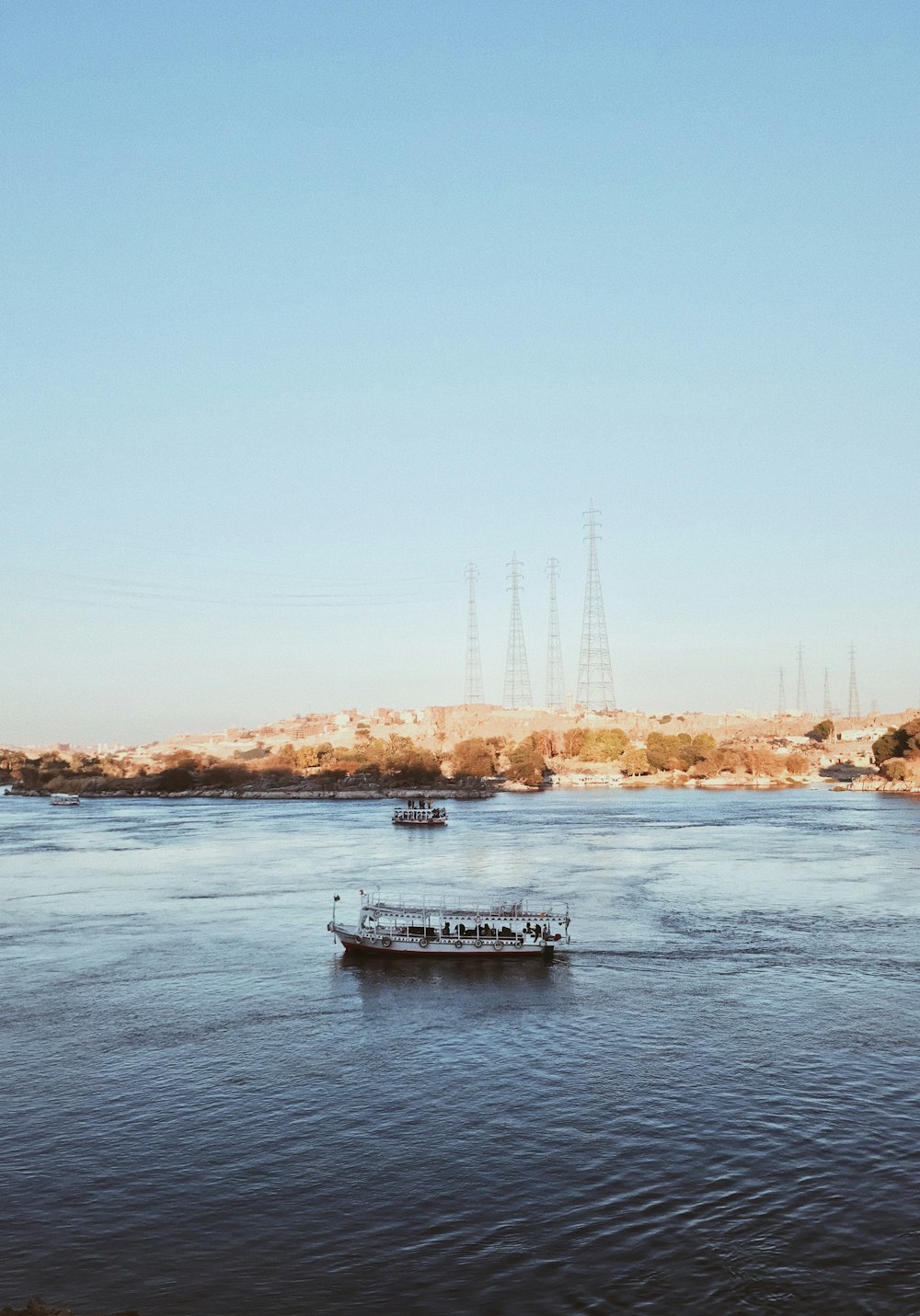 white boat on water near bridge during daytime