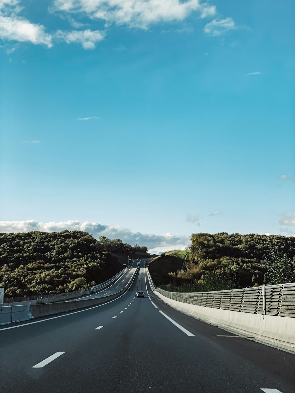 Carretera de hormigón gris bajo el cielo azul durante el día