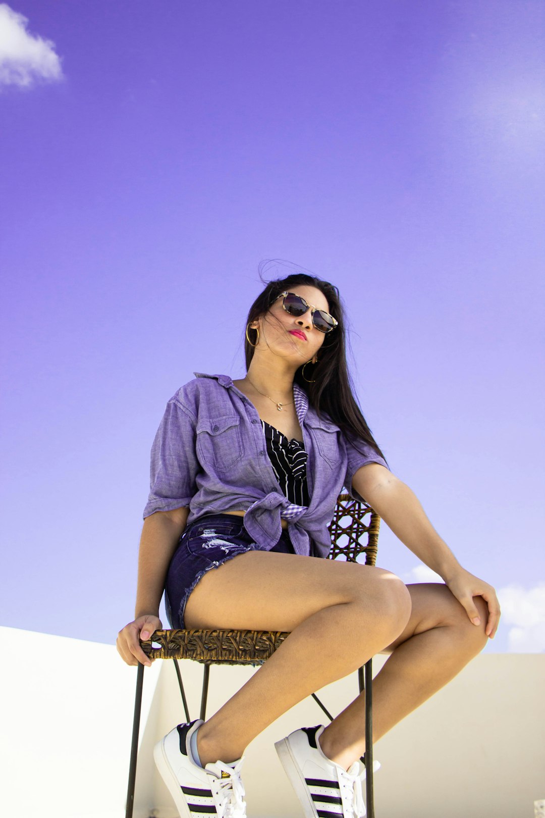 woman in blue denim button up shirt and black skirt sitting on white chair