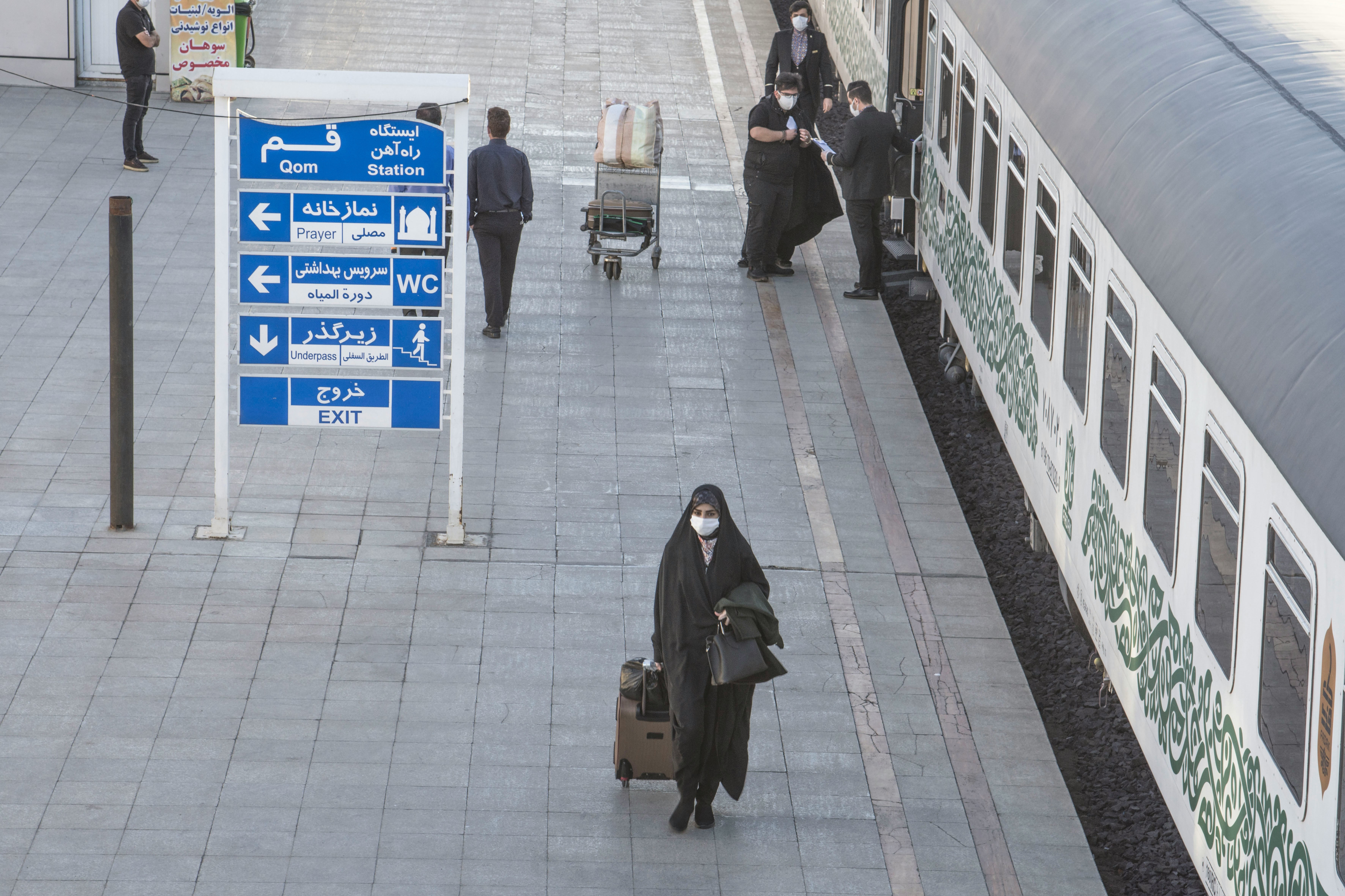 woman in black coat standing on sidewalk