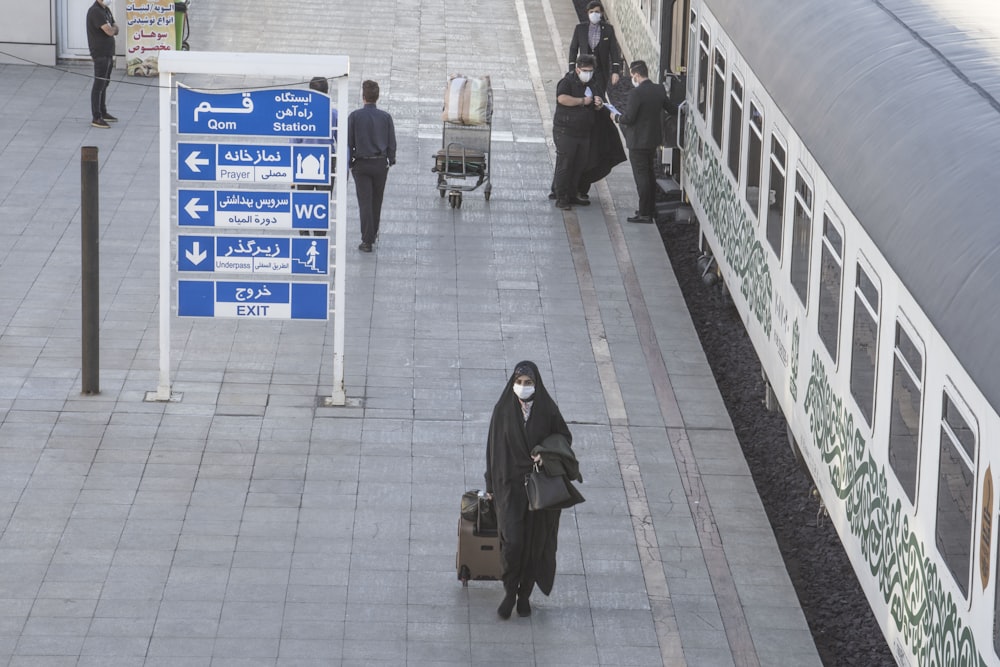 woman in black coat standing on sidewalk