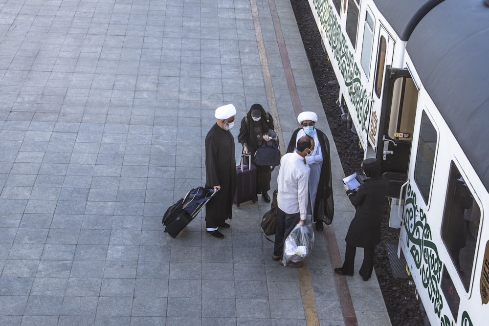 people in white thobe walking on sidewalk during daytime