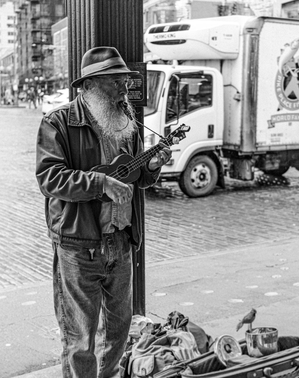 man playing guitar in grayscale photography