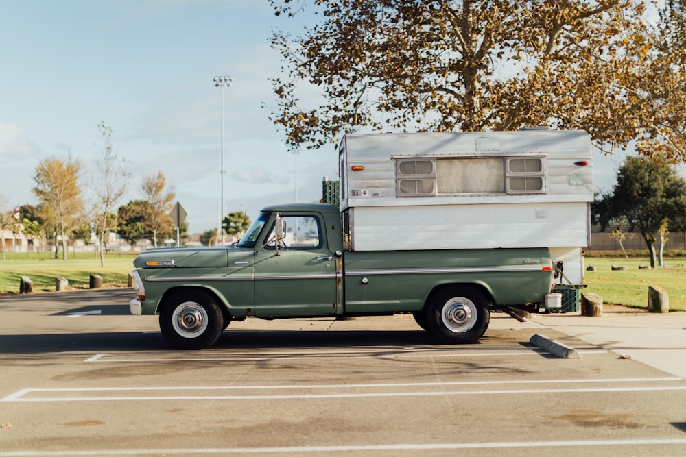 green chevrolet single cab pickup truck parked on road side during daytime