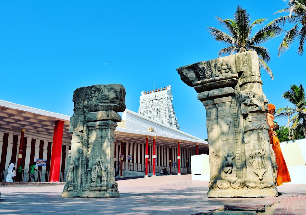 gray concrete pillar near green palm tree during daytime