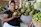 Photo of a cheerful woman holding a basket of fresh exotic vegetables in a bright market setting.