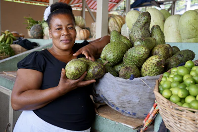 A smiling staff member helping a customer select ripe, locally sourced fruits.