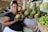 A smiling woman holding a basket of fresh local produce.