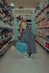 woman in black and white striped long sleeve shirt and blue denim jeans sitting on gray
