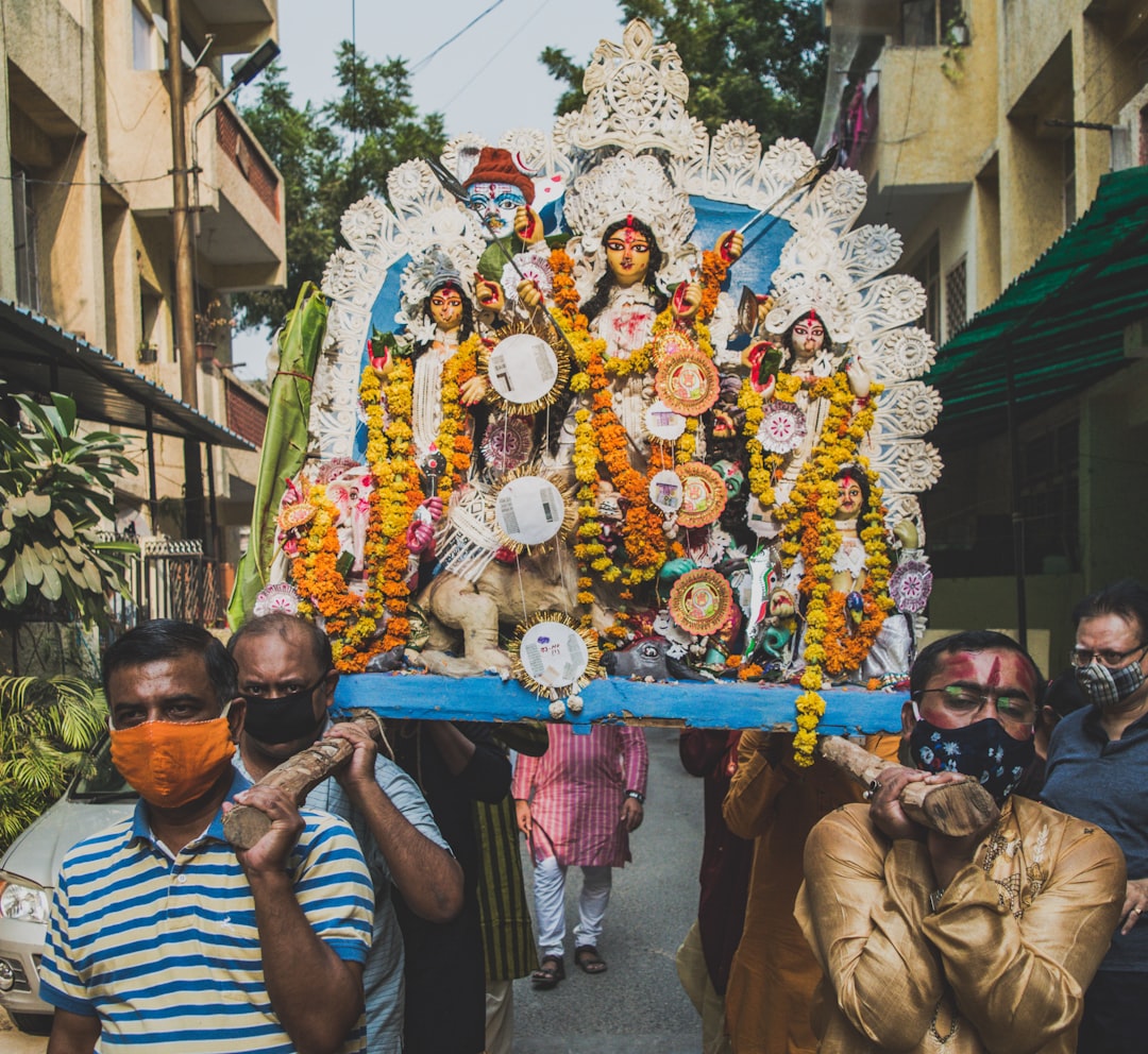  man in white and blue striped shirt holding gold and blue floral bouquet palanquin