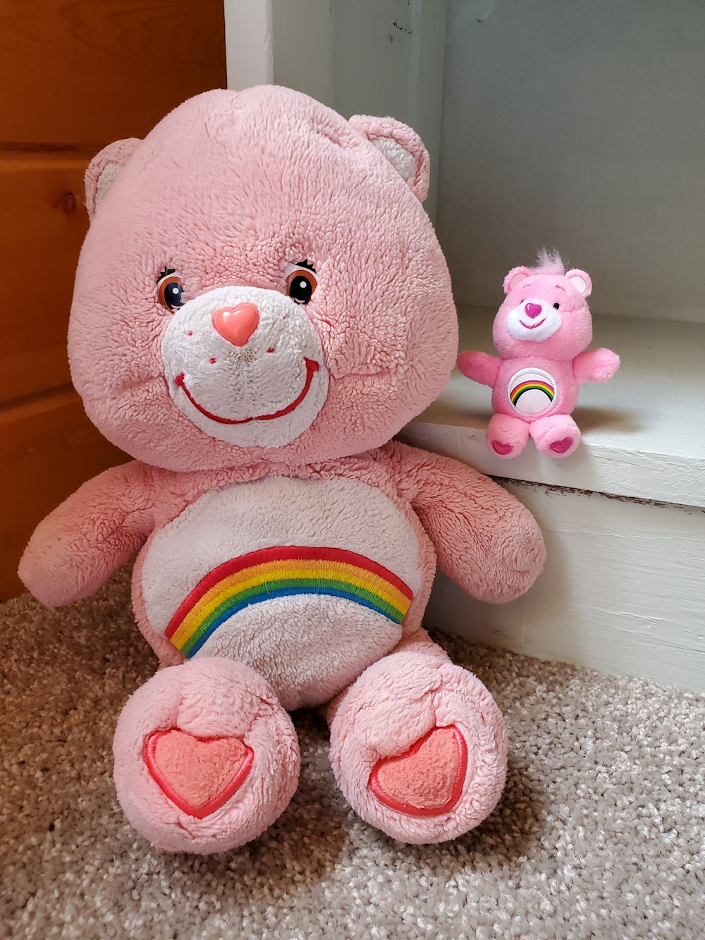 pink bear plush toy on white wooden table