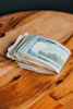 Close-up of hands counting Idaho state treasury bills on a wooden desk.