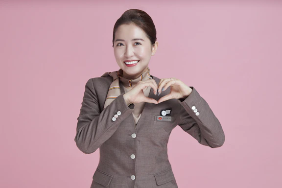 A friendly CPR instructor smiling warmly, holding a red heart-shaped cushion.