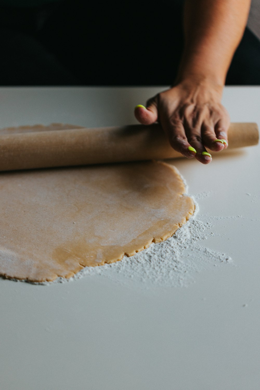 Persona sosteniendo masa marrón sobre mesa blanca