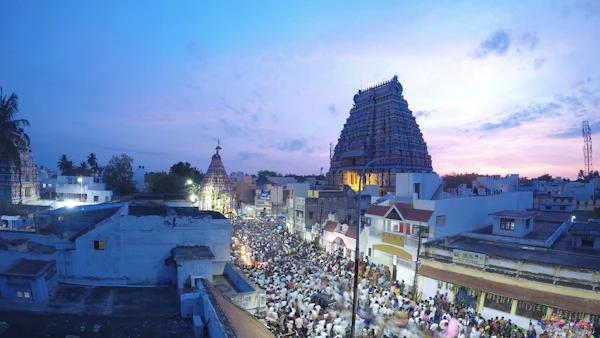 A temple gopuram over the evening crowd
