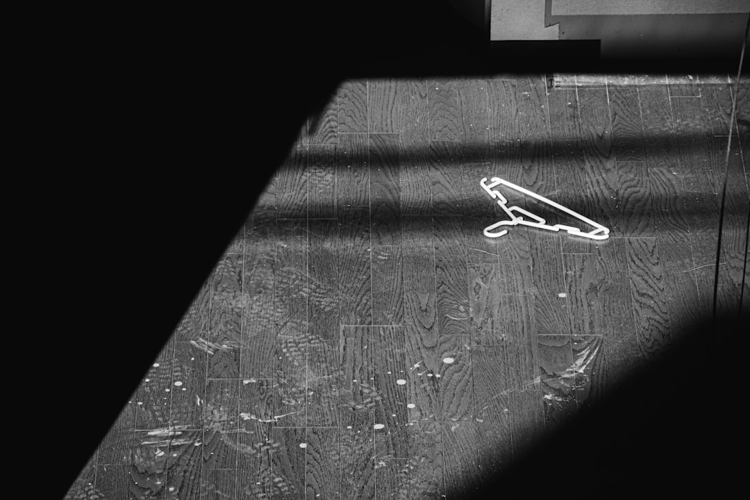 gray scale photo of paper clip on wooden table