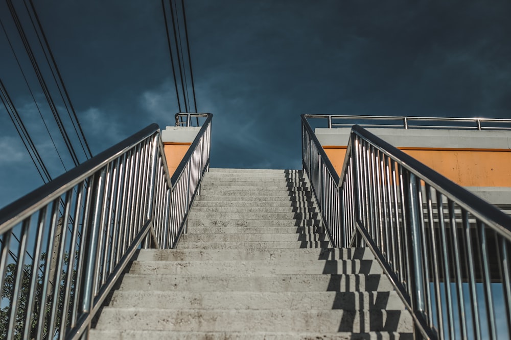 gray concrete staircase with orange railings