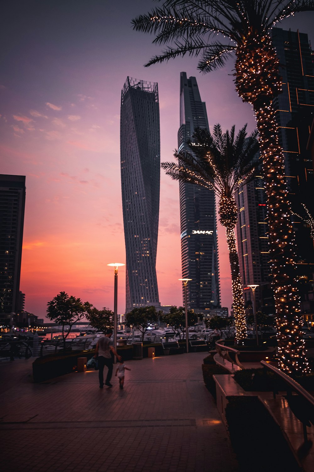 people walking on street near high rise buildings during night time