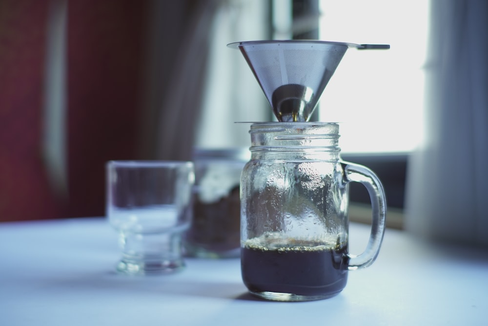 clear glass pitcher with white plastic cup