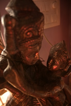 Close-up of a finely detailed brass statue glowing softly in natural light