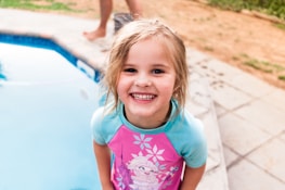 Smiling kids in swim gear ready for their lesson at the aquatic center.