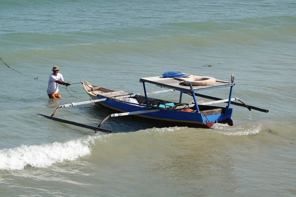 2 men riding on blue and white boat on sea during daytime