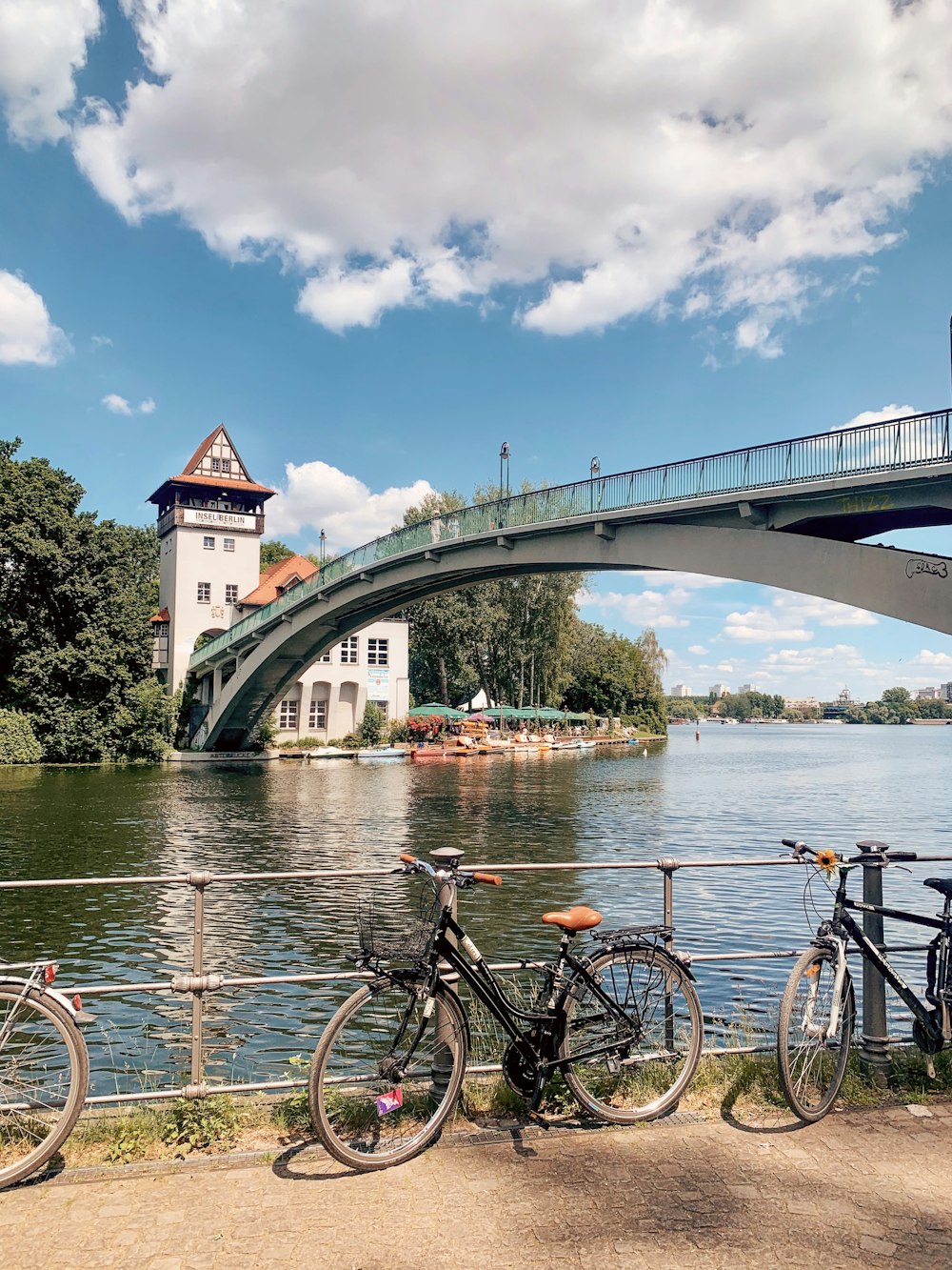 black bicycle on bridge over river during daytime