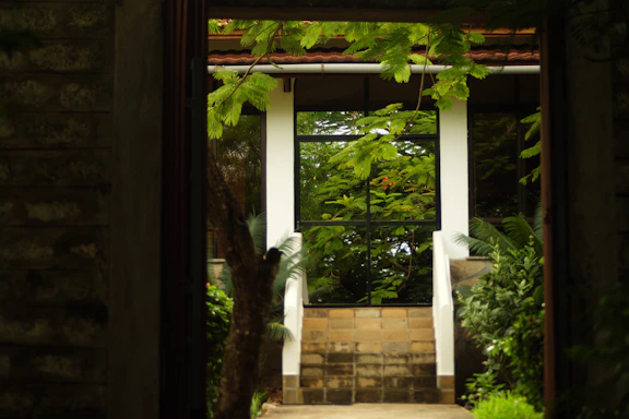 A serene view of the Ferienhaus am Waldschwimmbad entrance surrounded by lush greenery.
