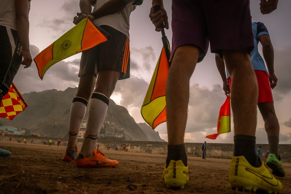 person in black shorts holding yellow and red flag